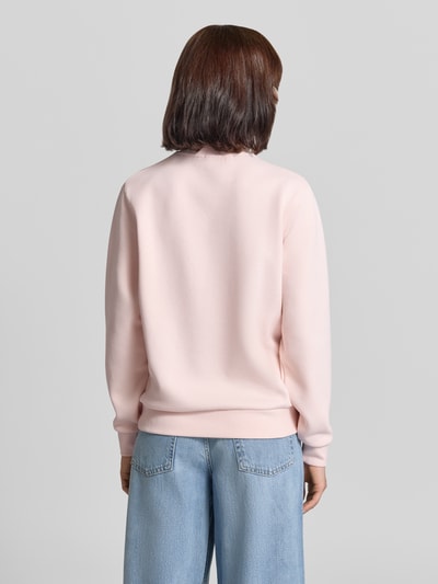 Frauenmodel trägt Relaxed Fit Sweatshirt aus Baumwoll-Mix von Lacoste in zartem Rosa, glatte Struktur, dezente Nähte, Ganzkörperansicht Rückansicht. Damen Sweatshirt von Lacoste.