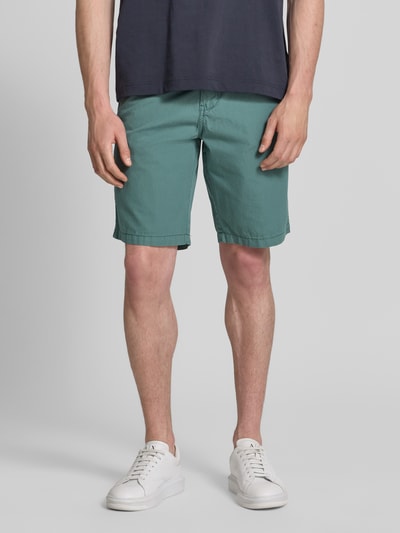 Männermodel trägt Regular Fit Chino Shorts mit Gürtel und Eingrifftaschen von Petrol in Grün, Reine Baumwolle, Ganzkörperansicht von vorne.