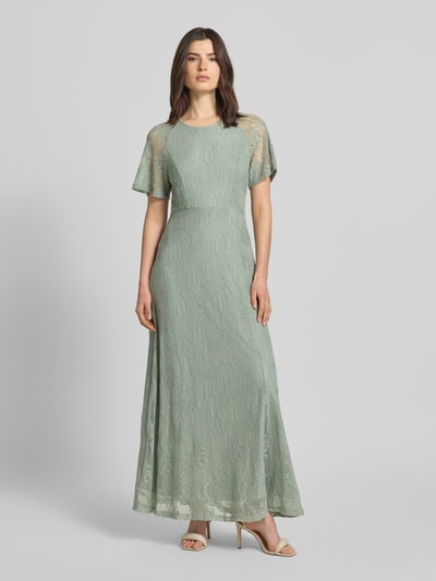 Frauenmodel trägt Maxikleid aus Spitze mit Rundhalsausschnitt Modell 'FEMMA' von Vila, Material-Mix mit Stretch-Anteil, sanftes Grün, Gerader-Schnitt, Ganzkörperansicht von vorne.