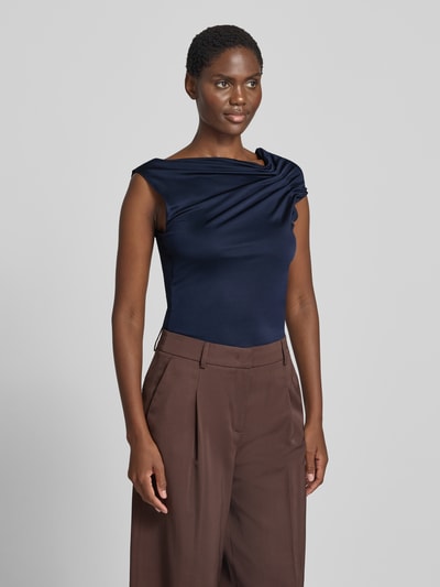 Frauenmodel trägt Relaxed Fit Top aus Viskose-Mix Modell 'JOIA' von BOSS in Dunkelblau, kombiniert mit brauner Hose, Damen Top, Ganzkörperansicht von vorne.