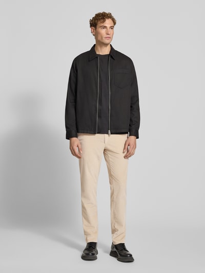 Männermodel trägt Modern Fit Cordhose aus Baumwoll-Mix Modell 'Fabio' von Brax in Beige, dezente Rippenstruktur, Ganzkörperansicht von vorne, Herren Cordhose von Brax.