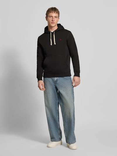 Männermodel trägt Hoodie mit Känguru-Tasche von REVIEW in Schwarz, Baumwollmischung, Slim-Fit, Kapuze mit Tunnelzug, elastische Abschlüsse, Ganzkörperansicht von vorne.