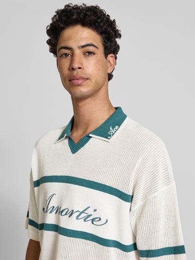 Männermodel trägt Regular Fit Poloshirt aus Baumwoll-Mix Modell 'ACE LIFE' von Only & Sons, Two Tone Design, grün-weiß, Nahaufnahme Oberkörper.