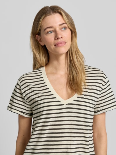 Frauenmodel trägt Damen T-Shirt aus Leinen-Mix mit V-Ausschnitt Modell 'AMY' von Mustang, gestreift, Regular-Fit, Label-Detail, Nahaufnahme Oberkörper. Rückenlänge bei Größe S: 61 cm, Leinen-Baumwoll-Anteil.