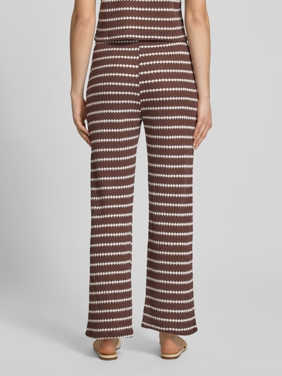 Frauenmodel trägt Loose Fit Stoffhose mit Baumwoll-Anteil Modell 'EVA LIFE' von Only, braun-weißes Allover-Muster, Strick, Ganzkörperansicht Rückansicht.