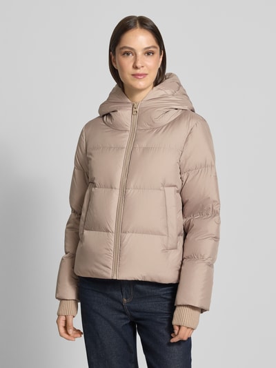 Frauenmodel trägt beige Regular Fit Daunenjacke mit Label-Patch von Marc O'Polo, glatte Oberfläche, dezente Steppungen, Ganzkörperansicht von vorne, Damen Daunenjacke von Marc O'Polo.