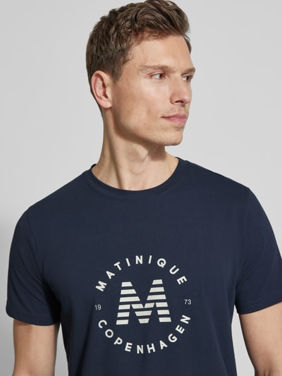 Männermodel trägt dunkelblaues T-Shirt mit Label-Print Modell 'Jeramy' von Matinique aus Baumwoll-Elasthan, Nahaufnahme Oberkörper.