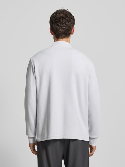 Männermodel trägt Regular Fit Sweatshirt aus Baumwoll-Mix Modell 'PE_HIVE' von BOSS Orange in unifarbener Optik mit Struktur-Muster, Ganzkörperansicht Rückansicht.