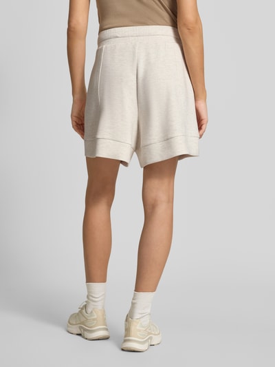 Frauenmodel trägt Shorts mit elastischem Bund Modell 'alder' von VARLEY aus Viskose-Mix mit Stretch-Anteil in Beige, High-Rise-Fit, ganzkörperansicht Rückansicht. Bundweite bei Größe S: 42 cm, Innenbeinlänge bei Größe S: 14 cm.