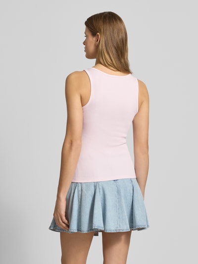 Frauenmodel trägt Tanktop in Ripp-Optik mit Label-Stitching von Guess Jeans aus Baumwoll-Elasthan-Mix, Slim-Fit, Rückenlänge 53 cm, Ganzkörperansicht Rückansicht.