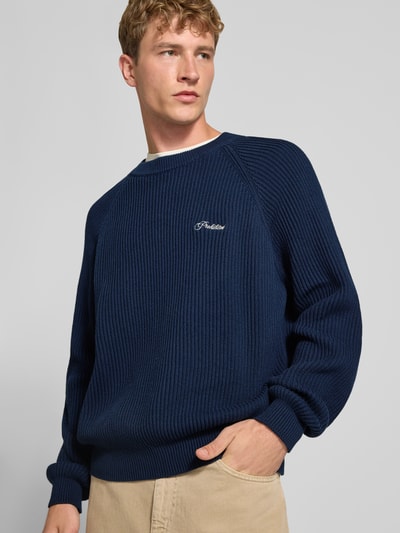 Mannenmodel draagt Relaxed Fit gebreide pullover uit puur katoen Model 'Campus' van PROHIBITED, donkerblauw met ribboorden, ruglengte maat M 69 cm, mouwlengte maat M 98 cm, vooraanzicht bovenlichaam.