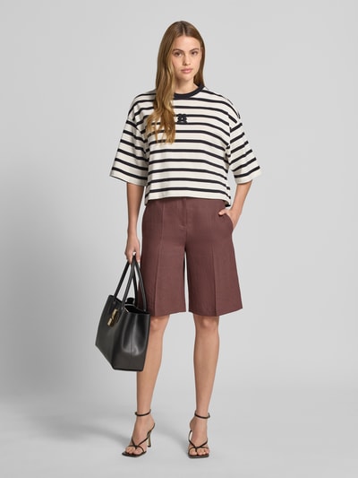 Modelka nosi Cropped T-Shirt mit Motiv-Stitching von Smith and Soul z bawełny, krój loose fit, okrągły dekolt, długość tyłu 52 cm, widok z przodu całościowy