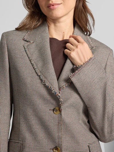 Kobiece model prezentuje żakiet Slim Fit Blazer mit Pattentaschen Model 'TINTO FILO' od Liu Jo White, mieszanka materiałów z dodatkiem wiskozy, kołnierz z połami, zapięcie na guzik, kieszenie z patką, długość tyłu w rozmiarze 36: 66 cm, szerokość w rozmiarze 36: 44 cm, długość rękawów w rozmiarze 36: 64 cm, wzór w kratę, przewaga odcieni brązu i beżu, tekstura lekko szorstka, zbliżenie na górną część sylwetki, zdjęcie z przodu.