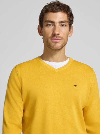 Männermodel trägt Strickpullover mit Label-Strickerei von Fynch-Hatton in Gelb aus Baumwolle, V-Ausschnitt, Nahaufnahme Oberkörper.