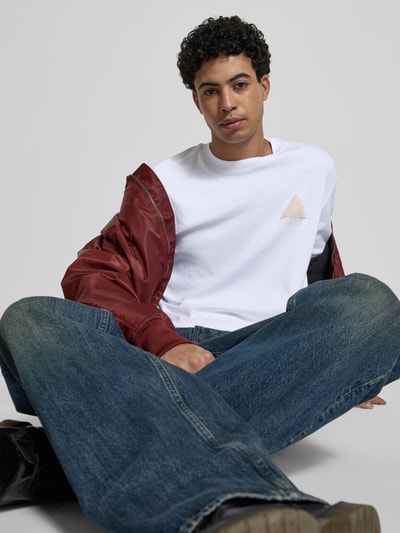 Männermodel trägt Regular Fit T-Shirt mit Logo-Detail von G-Star Raw in Weiß aus reiner Baumwolle, Rundhalsausschnitt, Nahaufnahme Oberkörper.