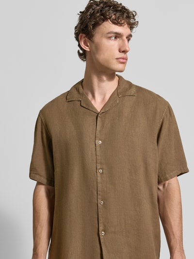 Männermodel trägt Regular Fit Leinenhemd mit Reverskragen von MCNEAL in Braun, Kurzarm, Knopfleiste, reine Leinen-Textur, Nahaufnahme Oberkörper.