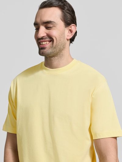 Männermodel trägt Regular Fit T-Shirt aus reiner Baumwolle von MCNEAL in Hellgelb, kurzärmelig, Rundhalsausschnitt, Nahaufnahme Oberkörper.