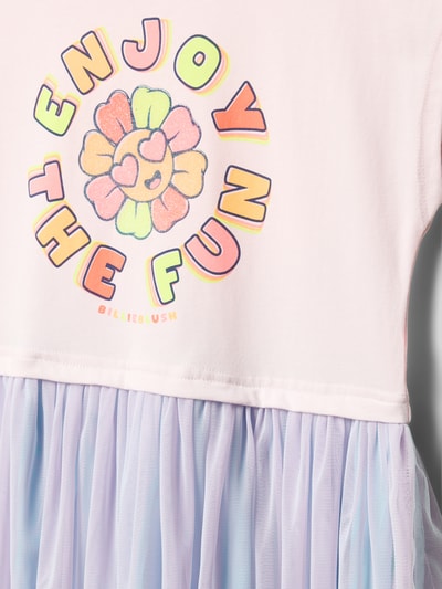 Mädchen trägt Knielanges Kleid mit Motiv-Print von BILLIEBLUSH in Pastellfarben, luźny krój, okrągły dekolt, krótkie rękawy, detal z logo, długość tyłu w rozmiarze 116: 62 cm, Nahaufnahme Oberkörper.