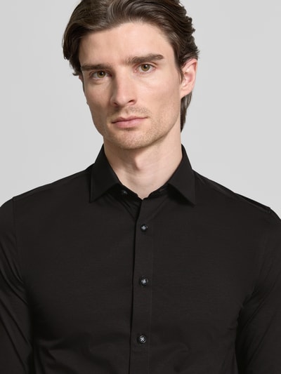 Männermodel trägt Body Fit Business-Hemd mit Knopfleiste von OLYMP Level Five in Schwarz, Baumwoll-Elasthan, Nahaufnahme Oberkörper.