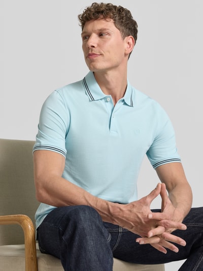 Männermodel trägt Regular Fit Poloshirt mit Logo-Stitching von bugatti in Hellblau, Reine Baumwolle, Polokragen, Kurze Knopfleiste, Label-Detail, Ganzkörperansicht von vorne.