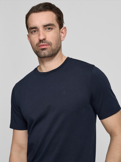 Männermodel trägt T-Shirt mit Label-Stitching und Rundhalsausschnitt von Scotch & Soda, Herren T-Shirt in Reine Baumwolle, Regular-Fit, dunkles Blau, Rückenlänge bei Größe M 68 cm, Nahaufnahme Oberkörper.