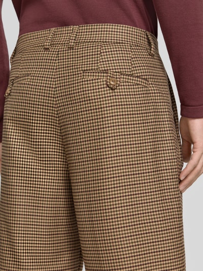 Männermodel trägt broek met rechte pijpen van DRYKORN, Model 'WYACO', fijn bruin-beige ruitpatroon, strookzak aan de achterkant, detailopname. Bandwijdte maat 32/32: 43 cm, binnenbeenlengte maat 32/32: 72 cm.