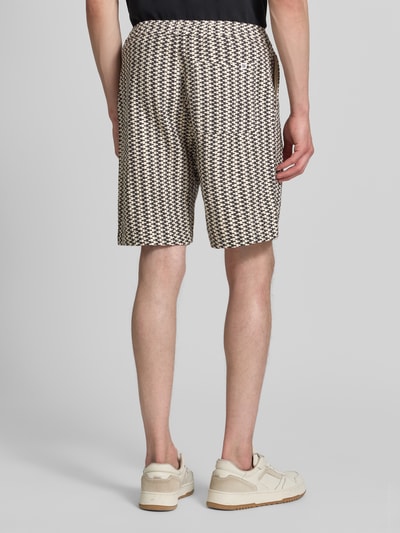 Männermodel trägt Relaxed Fit Stoffshorts aus Baumwoll-Mix von s.Oliver RED LABEL mit Optik: Allover-Muster, Strukturmuster, Label-Patch, elastischem Bundabschluss mit Tunnelzug, seitlichen Eingrifftaschen, Gesäßtasche, Material: reine Baumwolle, Farbkombination Beige-Schwarz, texturierte Oberfläche, Ganzkörperansicht Rückansicht.