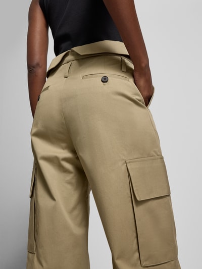 Frauenmodel trägt Cargohose aus reiner Baumwolle von Iro in Beige mit Cargotaschen und Gürtelschlaufen, Ganzkörperansicht Rückansicht.