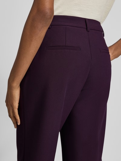 Vrouwenmodel draagt Straight Fit broek met viscose van Rich & Royal in donkerpaars, elastische materiaalmix, persplooien, verkort, detailopname heupen en dijen vanuit achteraanzicht, context: dames broek, haakjes- en ritssluiting, bandwijdte maat 36: 37 cm, binnenbeenlengte maat 36: 70 cm.