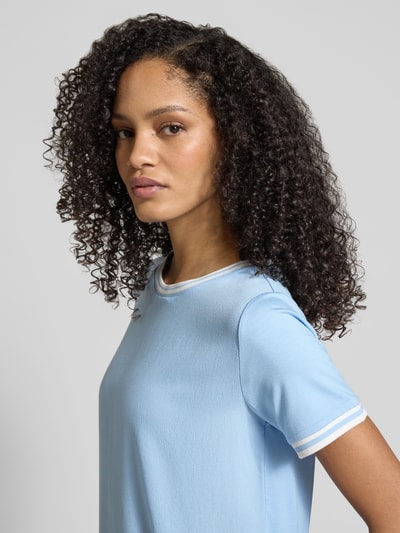 Kobiece modelka nosi T-Shirt aus Viskose-Elasthan-Mix mit Rundhalsausschnitt von More & More, krój regular fit, jasnoniebieski kolor, gładka tekstura, długość pleców w rozmiarze 36: 58 cm, zbliżenie na górną część ciała, widok z przodu.