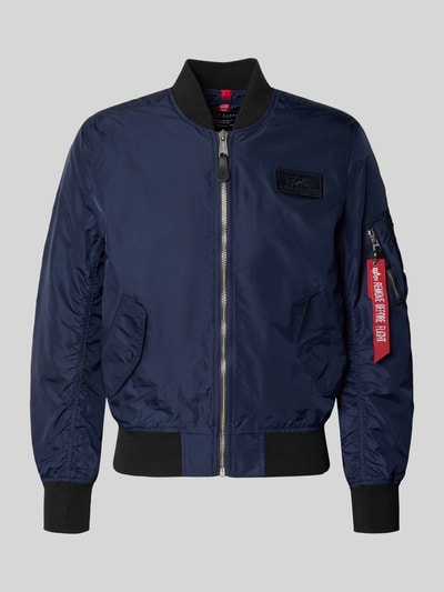 Produktfoto, Regular Fit Bomberjacke mit Logo-Patch von Alpha Industries, stójka, wpuszczane kieszenie, zamek błyskawiczny, kieszeń na rękawie, długość tyłu w rozmiarze M 65 cm, szerokość ramion w rozmiarze M 45 cm, szerokość w rozmiarze M 54 cm, długość rękawów w rozmiarze M 69 cm, granatowy kolor, gładka tekstura