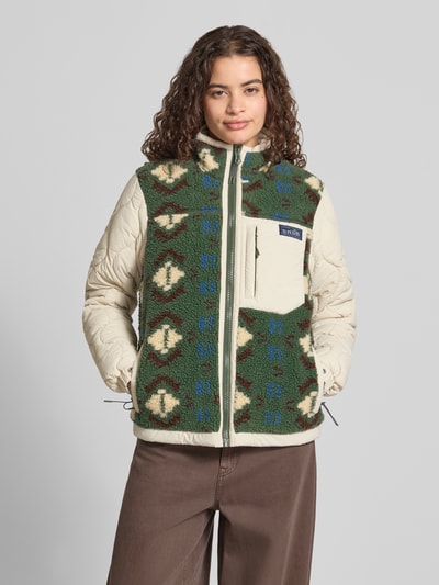 Frauenmodel trägt Fleecejacke mit Steppnähten und Label-Detail von Superdry in Grün-Beige mit Brusttasche, Reißverschluss, Regular Fit, Ganzkörperansicht von vorne.