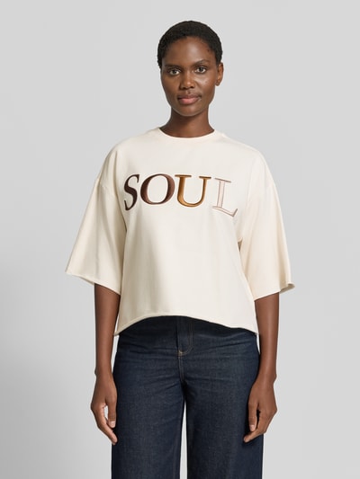 Frauenmodel trägt Cropped Boxy Fit Sweatshirt mit Label-Stitching von Smith and Soul, beige, weiter Schnitt, Rundhalsausschnitt, Vorderansicht, Damen Sweatshirt aus Baumwoll-Elasthan-Mix, Halbarm.