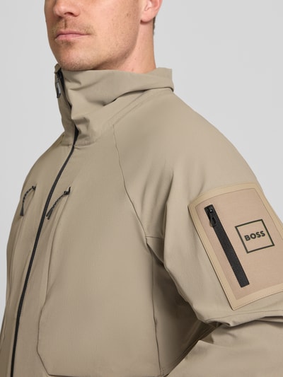Männermodel trägt Regular Fit Trainingsjacke mit Label Patch Modell 'OW_GLOBE' von BOSS Green in Optik: Unifarben, Nahaufnahme Oberkörper.