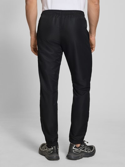 Männermodel trägt schwarzen Regular-Fit Tracksuit mit Logo-Stitching Modell 'Carson' von SERGIO TACCHINI, Ganzkörperansicht Rückansicht.