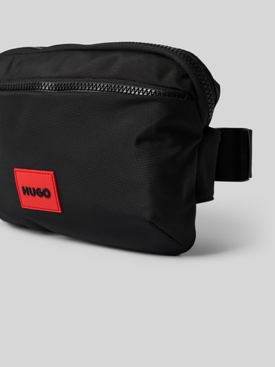 Produktfoto, schwarze Bauchtasche mit Struktur und rotem Label Patch, Reißverschluss, Hauptfach und Vorfach, Ethon 3.0_NEW BMBG C von HUGO