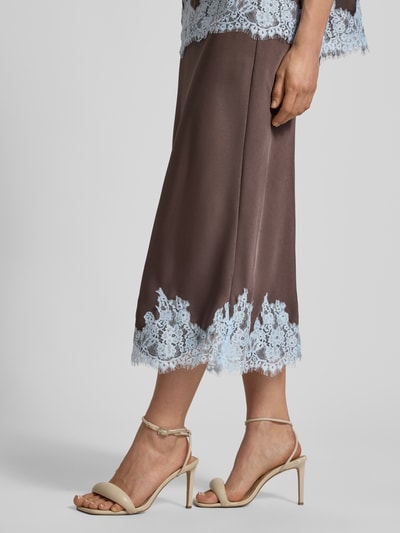 Frauenmodel trägt Midirock aus Satin mit Spitzenbesatz Modell 'NAIRA' von Neo Noir in Braun mit hellblauem Spitzenbesatz, Nahaufnahme Unterkörper, Damen, Gerader-Schnitt, Bundweite 28 cm, Gesamtlänge 84 cm, Größe 36, Satin-Haptik.