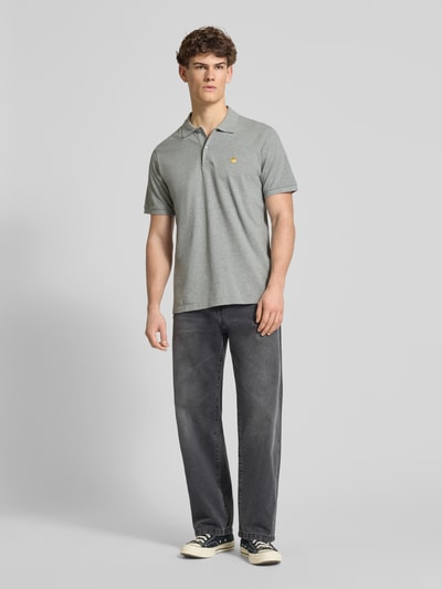Männermodel trägt Regular Fit Poloshirt mit Label-Stitching von Carhartt Work In Progress, graue Baumwolle, Ganzkörperansicht von vorne.