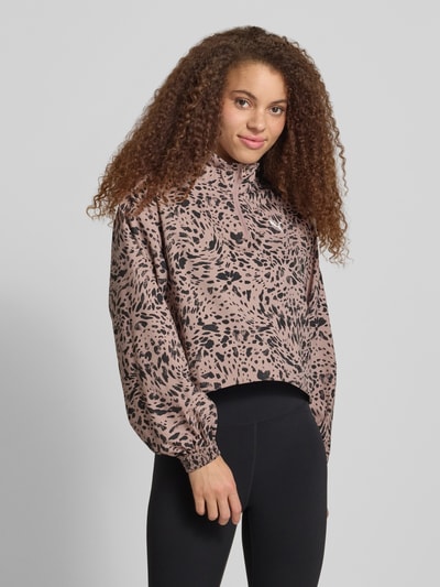 Frauenmodel trägt Relaxed Fit Sweatshirt mit Logo-Print von PUMA im Allover-Animal-Print, elastische Bündchen, Nahaufnahme Oberkörper.