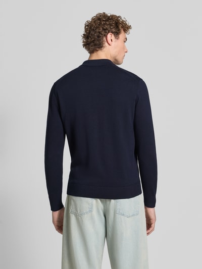 Männermodel trägt Slim Fit Poloshirt aus reiner bawełna von armedangels in Dunkelblau, schlichte Struktur, Ganzkörperansicht Rückansicht