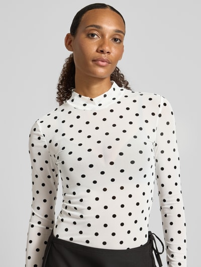 Vrouwenmodel draagt wit slim fit shirt met lange mouwen met zwart all-over motief Slim Fit Langarmshirt mit Allover-Muster model 'JESHI' van PIECES, dames, close-up bovenlichaamaanzicht