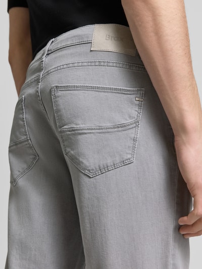 Männermodel trägt Sraight Fit Jeans mit Eingrifftaschen Modell 'Cadiz' von Brax in Grau, Used-Look, Baumwoll-Elasthan-Mix, Detailaufnahme Rückansicht.