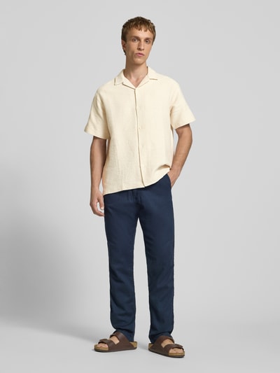 Männermodel trägt Regular Fit Poloshirt mit V-Ausschnitt von Jack & Jones aus reiner Baumwolle, Strickstruktur, Ganzkörperansicht von vorne.