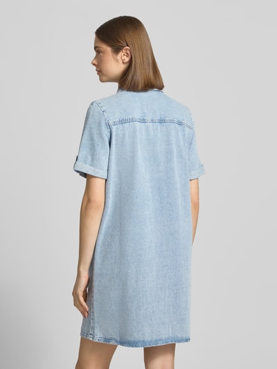 Männermodel trägt Körpernahes Jeanskleid aus Baumwoll-Viskose-Mix Modell 'LISA' von Only, jasnoniebieski, denim, mini, gładka faktura, krótki rękaw z mankietem, kieszenie na piersi, przeszycia label, widoczna karczek z tyłu, widok całej sylwetki z tyłu.