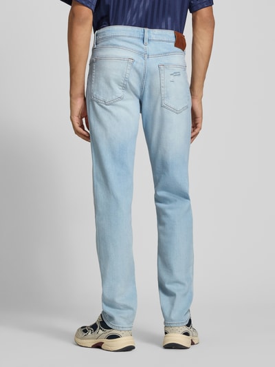 Männermodel trägt Slim Fit Jeans aus Baumwoll-Mix von Calvin Klein Jeans in hellem Blau, glatter Stoff, Ganzkörperansicht Rückansicht.