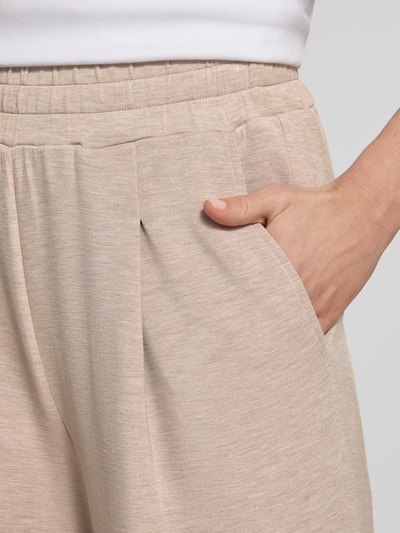 Männermodel trägt Sweatpants mit weitem Bein und Eingrifftaschen von VARLEY, beżowe, tkanina wiskozowa z dodatkiem stretchu, detailaufnahme Hüfte.