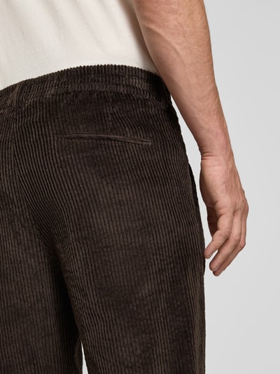 Männermodel trägt Straight Fit Hose aus Baumwoll-Mix Modell 'Chasy' von DRYKORN, braune Cord-Optik, Nahaufnahme Gesäßbereich.