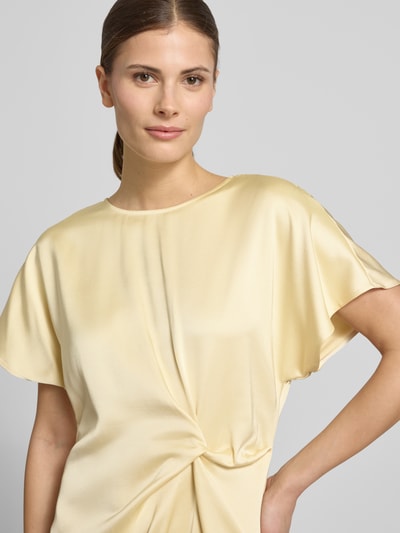 Vrouwenmodel draagt Cocktailkleid met Raffung en Kappärmeln van Christian Berg Cocktail, zachte glanzende viscosemix, ronde hals, getailleerd model, midi-jurk, crèmekleur, plooien en kapmouwen, detailopname bovenlichaam.
