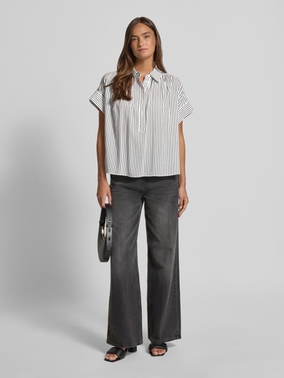 Frauenmodel trägt Relaxed Fit Bluse aus Viskose Modell 'Zafine' von Someday mit Streifenmuster, Knopfleiste, Hemdblusenkragen, Ganzkörperansicht von vorne. Rückenlänge bei Größe 36: 63 cm.