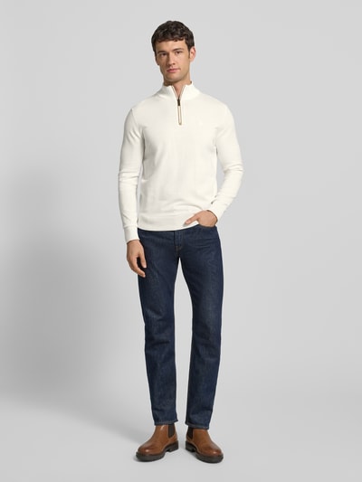 Męski model nosi Strickpullover mit Stehkragen od bugatti, biała bawełna, regular fit, ściągacze, widok całej sylwetki z przodu.
